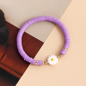 Detailed shot of purple heishi bead bracelet with a white resin daisy and golden accents