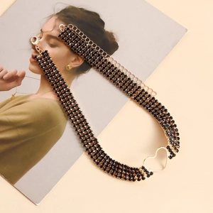 Detail of multi-layer gold chain with black rhinestones and hollow heart charm