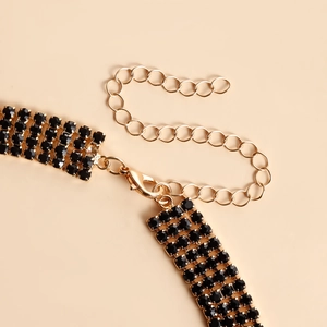 Detail of multi-row black rhinestone necklace with gold lobster clasp and extension chain