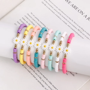 Colorful Heishi bead bracelets set with white daisy charms for bohemian summer beach style