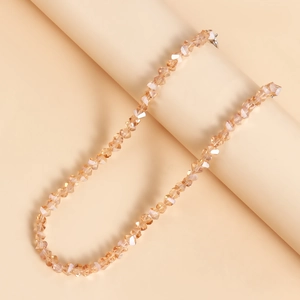Detail van gefacetteerde champagne kristallen kralen en metalen karabijnsluiting op een ketting