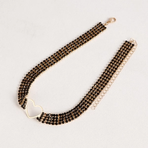 Detail of three-row black rhinestone choker featuring a gold hollow heart charm and clasp