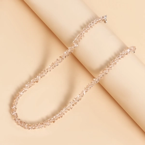 Detailopname van champagne kristallen kralenketting met metalen sluiting op een standaard