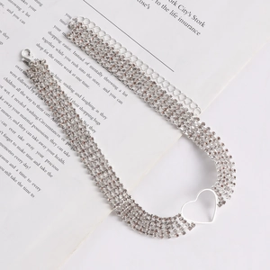 Detailed macro of a four-row rhinestone choker featuring a hollow silver heart pendant