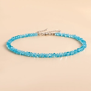 Detail van een lichtblauwe gefacetteerde kristallen kralenketting met zilveren sluiting