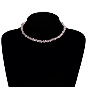 Detail van roze gefacetteerde kristallen kralenketting op zwart fluwelen halsbuste