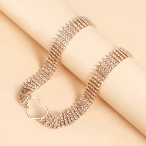 Close-up of a gold multi-layer rhinestone choker with an openwork heart buckle design