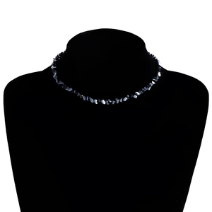Detail van gefacetteerde zwarte kristallen kralenketting op fluwelen display
