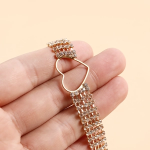 Detail view of gold tiered rhinestone choker necklace with hollow heart centerpiece