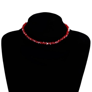 Macro-detail van veelzijdige rode kristallen kralen op een handgemaakte korte choker