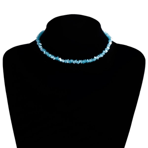 Detail van een lichtblauwe choker met onregelmatige stenen op een zwarte buste