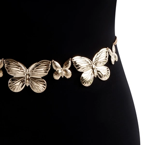 Détails de la chaîne de taille papillon en métal doré sur un mannequin noir élégant