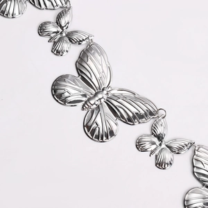 Détails d'une chaîne de taille en métal argenté poli avec pendentifs papillons