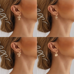 Détails de boucles d'oreilles nœuds dorés en métal avec finition polie et raffinée