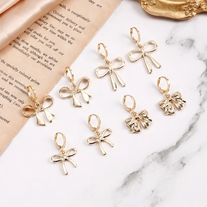 Détail de boucles d'oreilles nœud doré sur une élégante surface de marbre blanc