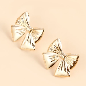 Detailed close-up of golden bow earrings with soft silk-like texture and metallic luster
