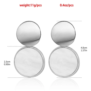 Gros plan de boucles d'oreilles argentées avec incrustation de marbre blanc et dimensions