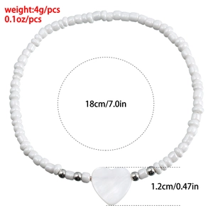 Dettaglio del bracciale di perline bianche bohémien da 18cm con ciondolo a cuore in conchiglia