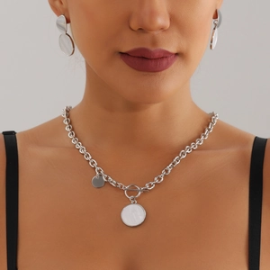 Collier à fermoir OT argenté avec pendentif en nacre blanche porté par le modèle