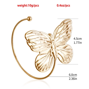 Vista macro di un ear cuff a farfalla in oro lucido con trame dettagliate delle ali