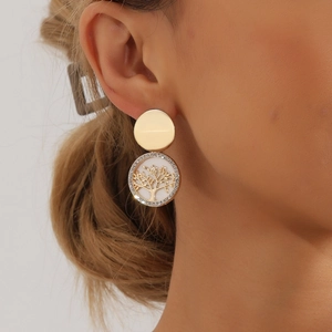 Close-up of gold tree of life earrings with white faux pearl inlay and rhinestones