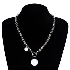 Détail d'un collier chaîne argentée épaisse avec fermoir à bascule et pendentifs circulaires