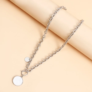 Collier à grosse chaîne argentée avec pendentifs ronds et fermoir T sur support neutre