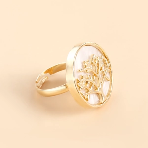 Detailed close-up of golden tree of life ring with white mother of pearl inlay and open band