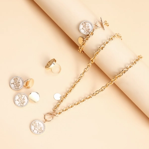 Golden Tree of Life jewelry set with necklace, bracelet, earrings and ring on warm background