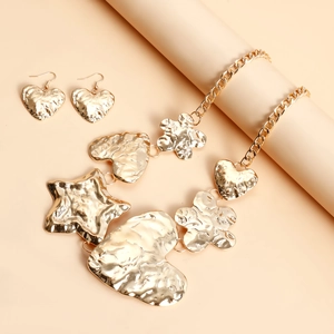 Dettaglio della collana con cuore e stella in metallo dorato martellato e orecchini coordinati