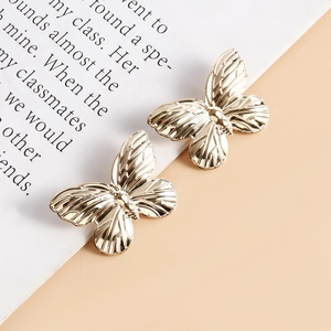 Dettaglio macro di accessori a farfalla in metallo dorato con venature delle ali su un libro