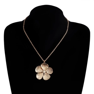 Detalle del gran colgante de flor en oro rosa con pétalos texturizados sobre maniquí