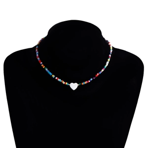 Dettaglio della collana bohémien di perline colorate con ciondolo a cuore in madreperla
