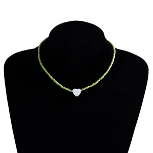 Dettaglio della collana bohémien di perline verdi con ciondolo a cuore in madreperla