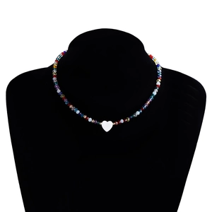 Dettaglio della collana bohémien di perline colorate con pendente a cuore in madreperla