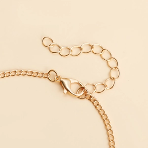 Gros plan du fermoir mousqueton doré et de la chaîne d'extension d'une bague-bracelet