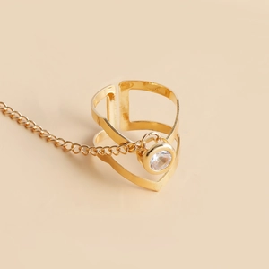 Détail d'une bague ajustable plaquée or avec une pierre de zircon et une chaîne délicate
