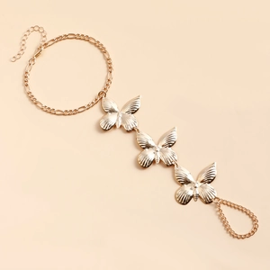 Détail du bracelet bague doré avec trois papillons délicats et chaîne de réglage ajustable