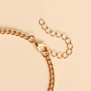 Gros plan du fermoir mousqueton doré et de la chaîne d'extension du bracelet bague