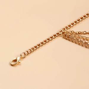 Detail of multi-layer golden curb chain beach anklet with a secure lobster clasp