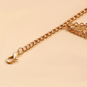 Close-up of golden multi-layer metal chain with large lobster clasp for beach anklets