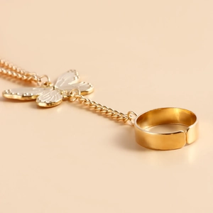 Vue macro détaillée d'un bracelet bague papillon doré avec bague ajustable et fine chaîne