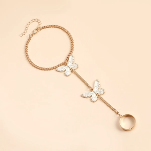 Détail d'une chaîne de main dorée avec papillons blancs et bague ajustable