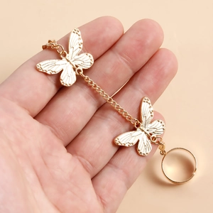 Détail d'un bracelet bague vintage papillon doré avec des ailes gravées complexes