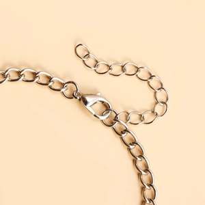Gros plan du fermoir mousqueton argenté et de la chaîne d'extension sur le bracelet