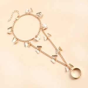 Détail du bracelet bague doré avec pendentifs papillon évidés et chaîne à double rangée