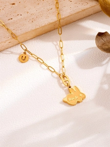 Detailopname van konijnenhanger met luck-gravure en H-schakel aan vergulde ketting
