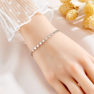 Elegant silver four-leaf clover bracelet for women with radiant texture on a model's wrist