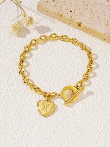 Detail van gouden hartvormige hanger met letter X en Nice Day gegraveerde OT-sluiting