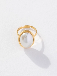 Nahaufnahme eines goldenen verstellbaren Rings mit großer weißer Kunstperle auf weiß